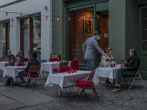 Patrons have dinner at ‘noto,’ a reopened restaurant in Berlin’s Mitte district, May 26, 2020. As Berlin emerges from its lockdown, residents are getting used to social distancing in bars and swimming pools — and to handing out their phone number several times a day to help in contact tracing.