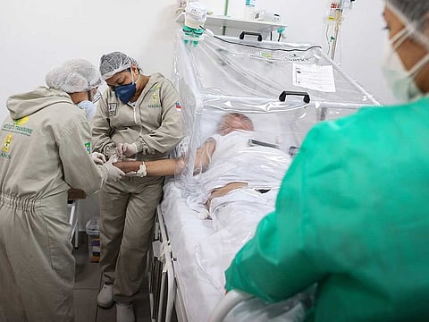Health workers assist a COVID-19 patient at the Gilberto Novaes Municipal Hospital in Manaus, Brazil.