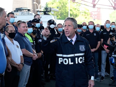 New York City PBA President Pat Lynch, center, speaks to police officers after speaking to reporters during a news conference in New York, Tuesday, June 9, 2020. A New York City police officer who was caught on video violently shoving a woman to the ground during a protest over the death of George Floyd was charged Tuesday with assault and other counts, prosecutors announced. Lynch said the mayor and police leaders were "sacrificing cops to save their own skin" by sending officers out to protests with "no support and no clear plan.