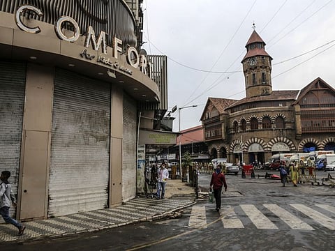 Pedestrians walk along a near-empty street near Crawford Market during a lockdown imposed due to the coronavirus in Mumbai, India.