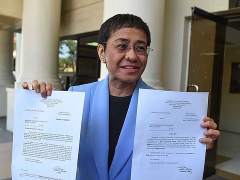 Maria Ressa, CEO and executive editor of online portal Rappler, showing the warrant of arrest order after posting bail at a court in Manila. File photo