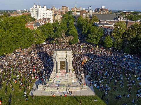 This Tuesday, June 2, 2020 file photo shows a large group of protesters gather around the statue of Confederate General Robert E. Lee on Monument Avenue near downtown in Richmond, Va. Virginia Gov. Ralph Northam announced plans Thursday, June 4, for the removal of the iconic statue.