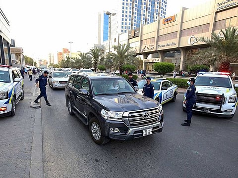 Kuwaiti police officers man a checkpoint at the entrance leading to the Hawally district of Kuwait City on May 29, 2020, after the district was put on lockdown to combat the spread of the Coronavirus.