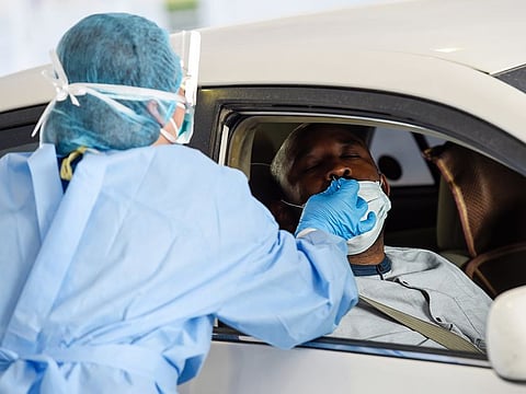 A paramedics taking swab sample at the SEHA drive-through National Screening Center at Golf and Shooting club in Sharjah.