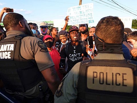 Protestors confront police officers near Centennial Olympic Park in Atlanta, Saturday, June 13, 2020, in response to the death of Rayshard Brooks, a black man who was shot and killed by Atlanta police Friday evening following a struggle in a Wendy's drive-thru line.