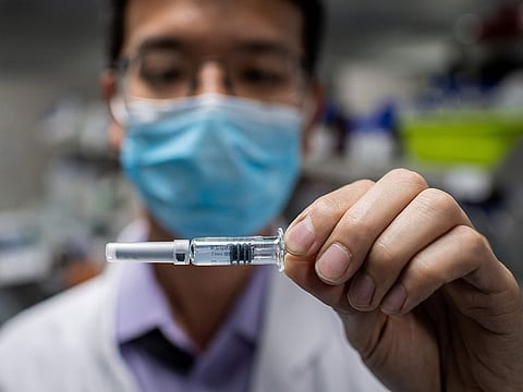 File photo: An engineer displaying an experimental vaccine for the COVID-19 that was tested at the Quality Control Laboratory at the Sinovac Biotech facilities in Beijing.
