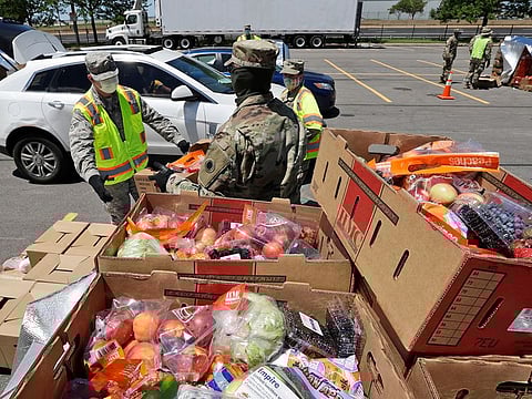 Members of the Ohio National Guard help load cars with food at the Greater Cleveland Food Bank food distribution, Thursday, June 11, 2020, in Cleveland.