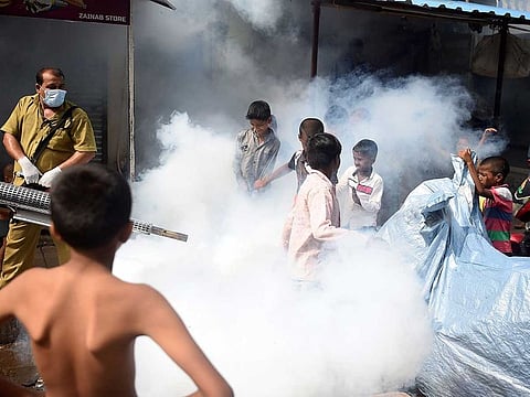 In this picture taken on June 12, 2020, a civic authority worker (L) fumigates a slum area to kill disease-carrying mosquitoes in Mumbai ahead of the monsoon season. With hospitals already severely stretched, COVID-19-hit India is now bracing for the monsoon and its deadly annual onslaught of mosquito-borne illnesses, with an overwhelmed army of public health workers the only defence.