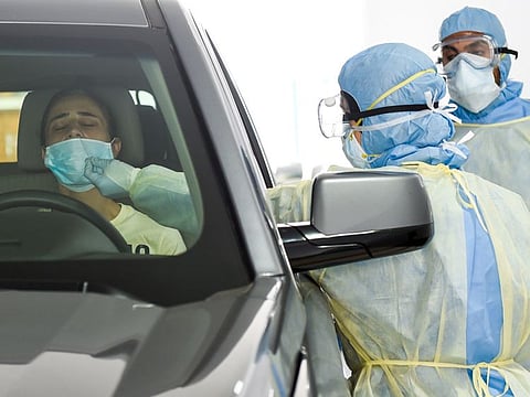 Paramedics collecting the swab samples at a coronavirus drive-through screening station by Dubai Health Authority at Al Nasr Club in Dubai on 9th April 2020. The drive-through facility, with a capacity of more than 250 tests per day, supports efforts to protect the health and safety of the community by giving people an easily accessible centre to test for COVID-19.