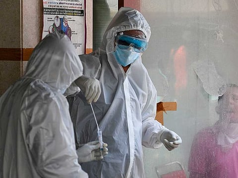 In this photograph taken on June 16, 2020, health officials collect a swab sample from a man to test for the COVID-19 coronavirus after authorities eased restrictions imposed as a preventive measure against the spread of the COVID-19 coronavirus, in New Delhi.