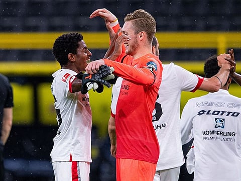 Mainz's Ridle Baku, left, and Florian Mueller celebrate after defeating Dortmund