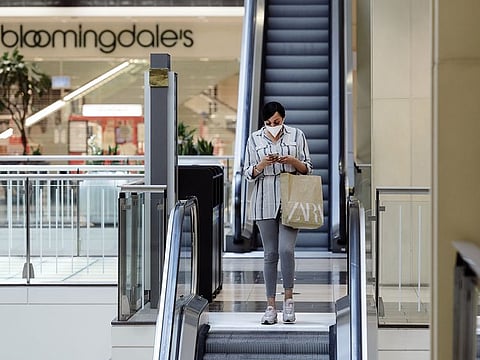 A shopper wearing a protective mask rides an escalator at Westfield San Francisco Centre in San Francisco, California, on Thursday, June 18, 2020.