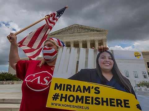 Ivania Castillo from Prince William County, Va., holds a banner to show her support for dreamer Miriam from California, as she joins Deferred Action for Childhood Arrivals (DACA) recipients celebrate in front of the U.S. Supreme Court after the Supreme Court rejected President Donald Trump's bid to end legal protections for young immigrants, Thursday, June 18, 2020, in Washington.