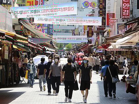 People walk on a shopping district in Seoul, South Korea.