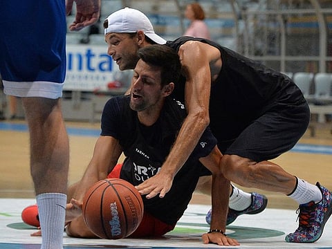 In this photo taken on Thursday June 18, 2020, Bulgarian tennis player Grigor Dimitrov, rear, plays basketball with Serbia's Novak Djokovic in Zadar, Croatia.