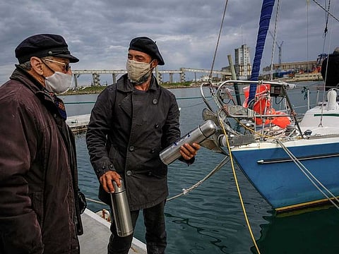 Argentine Juan Manuel Ballestero (R) speaking with his father Carlos (L) upon arrival in Mar del Plata, from Portugal, on June 20, 2020, after sailing for 85 days due to the COVID-19 pandemic restrictions. Having tested negative for COVID-19 upon arrival, Ballestero was cleared to set foot on dry land to stay with his parents, 82-year-old Nilda and Carlos, aged 90.