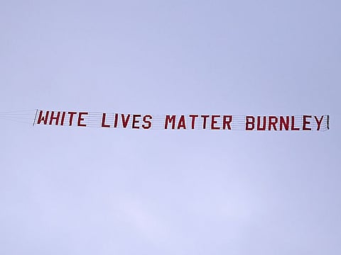 A plane towing a banner reading White Lives Matter Burnley flies above the stadium during the during the English Premier League soccer match between Manchester City and Burnley at Etihad Stadium, in Manchester, England, Monday, June 22, 2020.