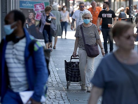People with face masks walk on a shopping road in Berlin, Germany.