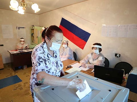A woman wearing a protective mask and gloves, used as a preventive measure against the spread of the coronavirus disease (COVID-19), casts her ballot at a polling station during a seven-day vote on constitutional reforms, in the village of Gigirevo in Moscow region, Russia June 25, 2020.