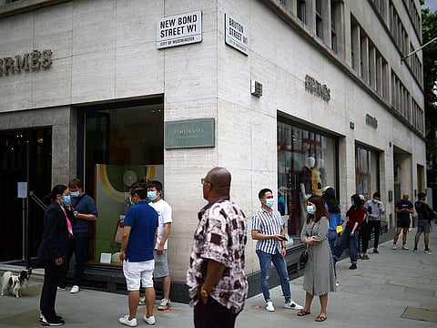 People are seen outside a Hermes store on June 15.