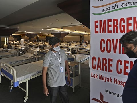 Health workers walk across a COVID-19 care centre being set up in New Delhi, India Tuesday, June 23, 2020. While India’s leaders have promised coronavirus testing and care for all who need it, regardless of income, treatment options are as stratified and unequal as the country itself. Care ranges from crowded wards at public hospitals that some worry will make them sicker than if they stayed home to spacious suites at private hospitals that only the wealthy can afford.