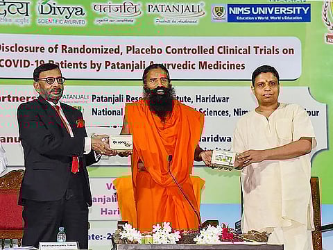 Baba Ramdev (C) along with Acharya Balkrishna, Patanjali Ayurved CEO (R) launch Ayurvedic medicines Coronil tablet and Swasari vati that they claimed can treat coronavirus patients within seven days, in Haridwan, on Tuesday, June 23.