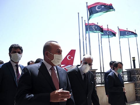 In this June 17, 2020, file photo, Turkey's Foreign Minister Mevlut Cavusoglu, left, and Mohammed Tahir Siyala, Foreign Minister of Libya's government, speak at the airport, in Tripoli, Libya.