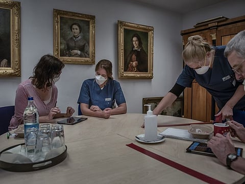 Dr. Camilla Rothe, an infectious disease specialist, helps a volunteer fill out a questionnaire in a coronavirus study at a nursing home in Munich, Germany, June 16, 2020. Rothe’s team was among the first to warn about asymptomatic transmission.