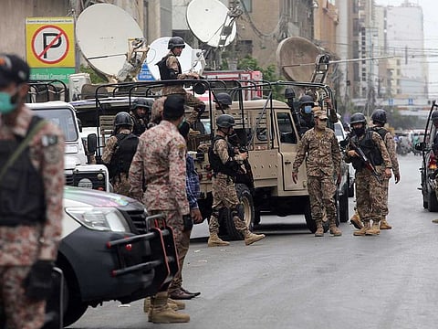 Security personnel surround the Stock Exchange Building after an attack by gunmen in Karachi, Pakistan, Monday, June 29, 2020. Special police forces deployed to the scene of the attack and in a swift operation secured the building.