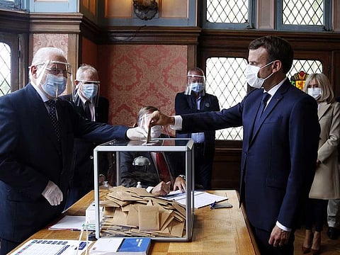 French President Emmanuel Macron casts his ballot for the second round of the mayoral elections at a polling station in Le Touquet, nothern France, on June 28, 2020.