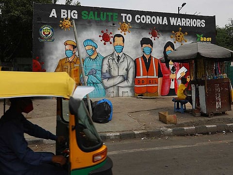 An autorickshaw drives past a graffiti thanking frontline workers in the fight against the coronavirus, in New Delhi