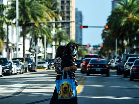 A woman wears a mask as she walks in Miami Beach, Florida on July 2, 2020.