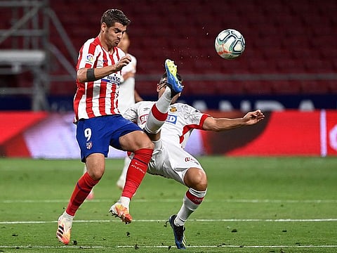 Atletico Madrid's Spanish forward Alvaro Morata (left) is challenged by Real Mallorca's Serbian defender Aleksandar Sedlar during the Spanish League match in Madrid on Friday.