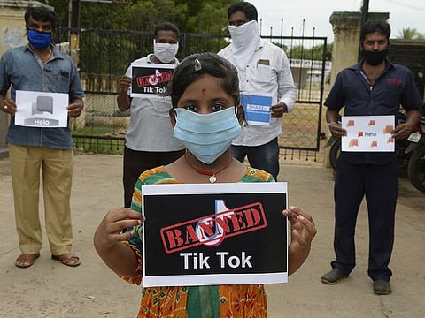 Members of the City Youth Organisation hold posters with the logos of Chinese apps in support of the Indian government for banning the wildly popular video-sharing 'Tik Tok' app, in Hyderabad on June 30, 2020.