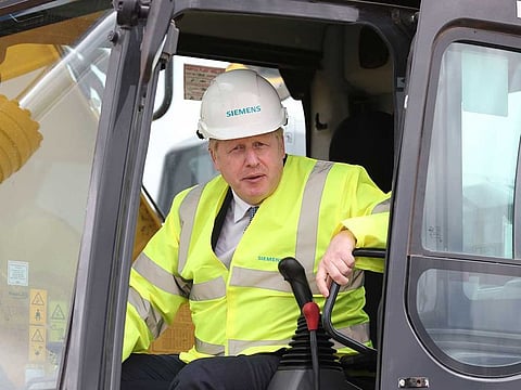 Britain's Prime Minister Boris Johnson poses in the cab of a digger during a visit to the Siemens Rail factory construction site in Goole, northeast England on July 6, 2020. Britain will list on Monday the first foreign nationals to face asset freezes and visa bans for alleged human rights abuses.