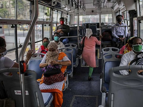 Passengers wearing protective masks travel on a bus in Mumbai, India, on Monday, July 6, 2020.