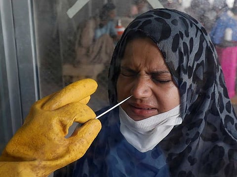 A paramedic wearing protective gloves takes a nose-swab sample to be tested for the coronavirus disease (COVID-19), in Karachi, Pakistan July 6, 2020.
