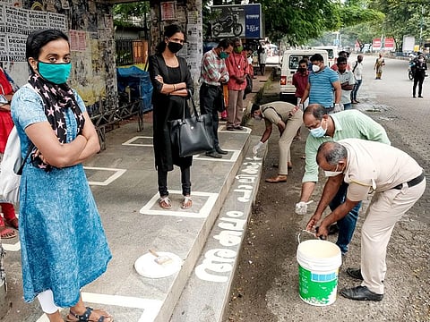 Police personnel painted circle for social distancing at bus stops during the ongoing COVID-19 pandemic, in Kochi.