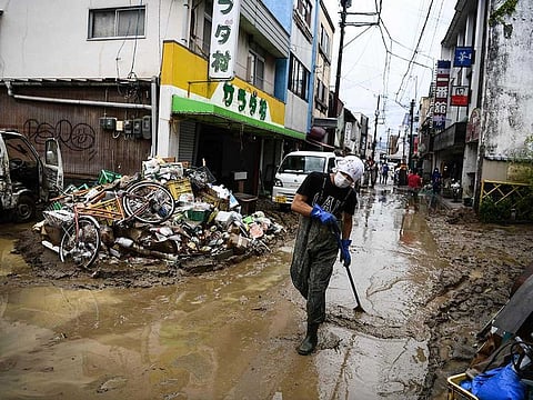 A man clears debris following heavy rains and flooding in Hitoyoshi, Kumamoto prefecture on July 9, 2020. Japan will deploy more troops to search for survivors of devastating floods and landslides that have killed at least 52 people in the southwest of the country, Prime Minister Shinzo Abe pledged.