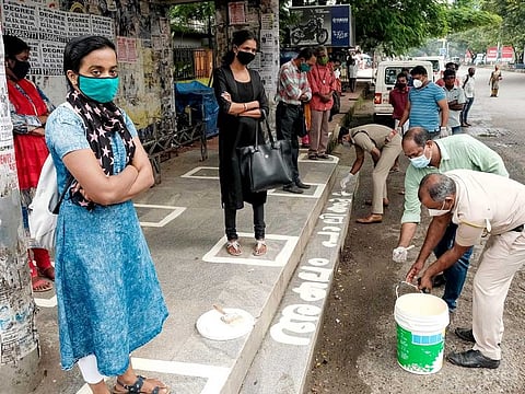 Police personnel paint markers for social distancing at bus stops during the ongoing COVID-19 pandemic, in Kochi on Monday, July 6, 2020.