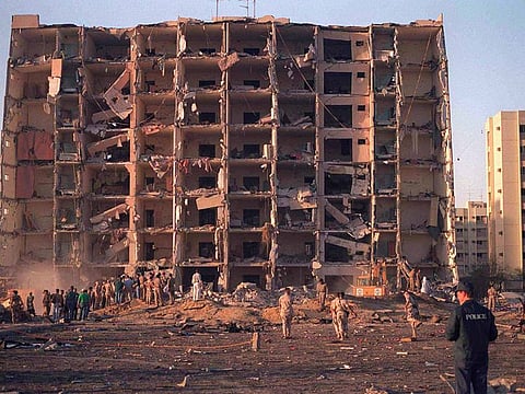 This file, June 25, 1996 image shows US and Saudi military personnel surveying the damage to Khobar Towers caused by the explosion of a fuel truck outside the northern fence of the facility on King Abdul Aziz Air Base near Dhahran, Saudi Arabia