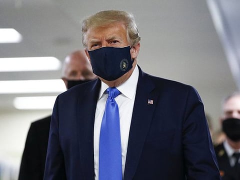 Trump dons a mask with the presidential seal on it