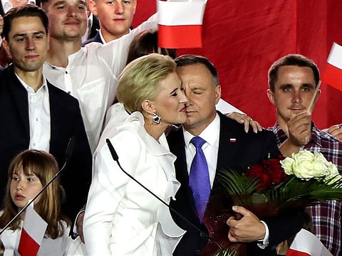 Incumbent President Andrzej Duda is hugged by his wife Agata Kornhauser-Duda in Pultusk, Poland, Sunday, July 12, 2020.