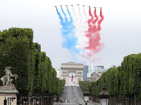 French elite acrobatic flying team "Patrouille de France" (PAF) performs a flying display of the French national flag over the Arc de Triomphe.