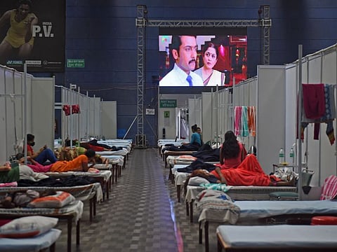 Patients watch a movie on a screen installed inside a ward at the Commonwealth Games (CWG) Village sports complex, temporarily converted into COVID-19 coronavirus care centre, in New Delhi on July 14, 2020.