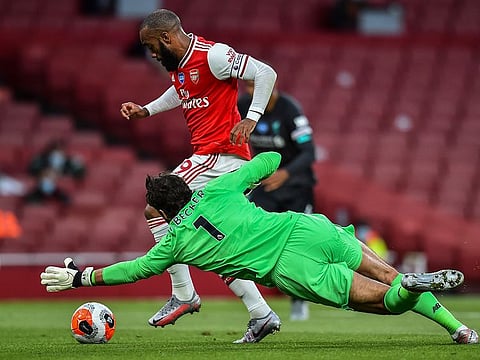 Arsenal's Alexandre Lacazette runs past Liverpool's goalkeeper Alisson before scoring