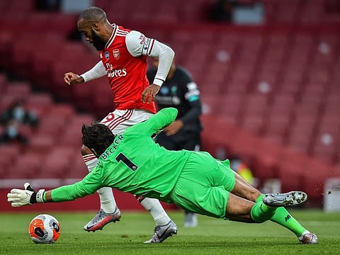 Arsenal's Alexandre Lacazette runs past Liverpool goalkeeper Alisson before scoring his team first goal during their English Premier League match at the Emirates Stadium in London on Wednesday.