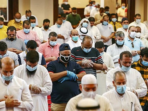 Worshippers, distanced safely from each other and clad in face masks due to the COVID-19 coronavirus pandemic, perform the Friday prayers at a mosque in Kuwait City.