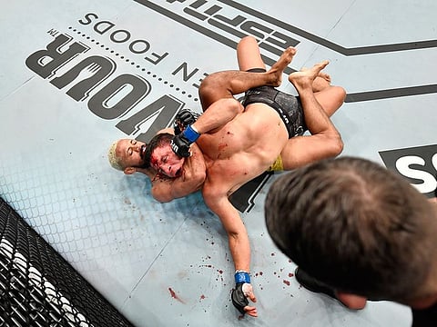 Deiveson Figueiredo of Brazil secures a rear choke submission against Joseph Benavidez in their UFC flyweight championship bout during UFC Fight Night at the Flash Forum on UFC Fight Island in Abu Dhabi