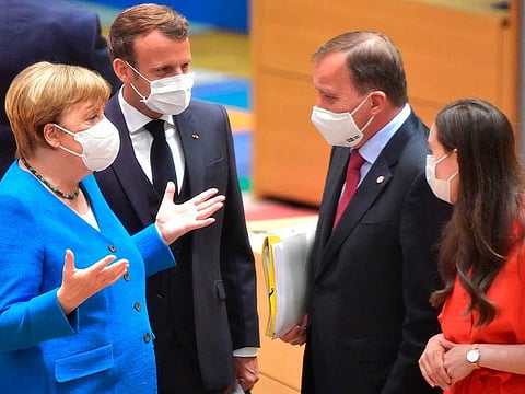 German Chancellor Angela Merkel (left) and French President Emmanuel Macron (second left) speak with Sweden's Prime Minister Stefan Lofven (second right) and Finland's Prime Minister Sanna Marin during a round table meeting at an EU summit in Brussels on July 18, 2020. Leaders from 27 European Union nations meet face-to-face for a second day of an EU summit to assess an overall budget and recovery package spread over seven years estimated at some 1.75 trillion to 1.85 trillion euros.